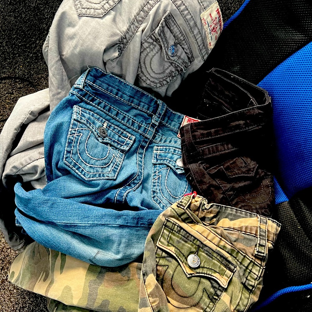 4 pair of true religion pants for boys. Blue pair has marker on front.